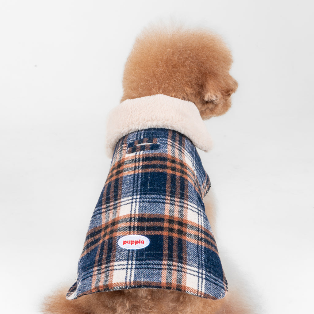 Dog wearing a plaid coat with a visible brand logo on a white background